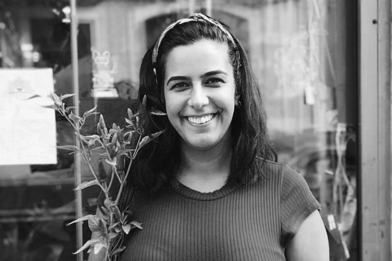 Rita Cabecinhas smiling, in black and white